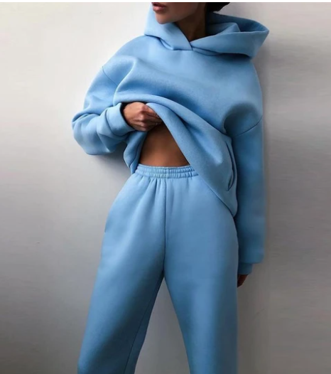 Vrouw in tweedelig joggingpak met hoodie