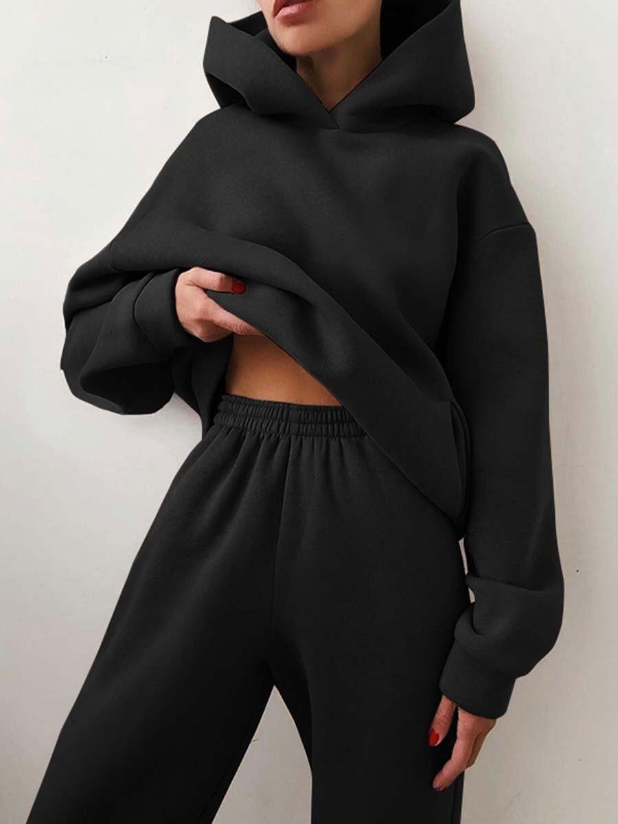 Vrouw in tweedelig joggingpak met hoodie