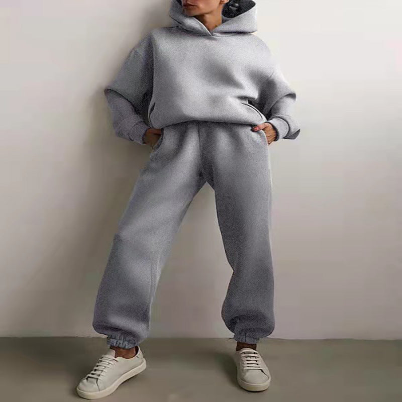 Vrouw in tweedelig joggingpak met hoodie
