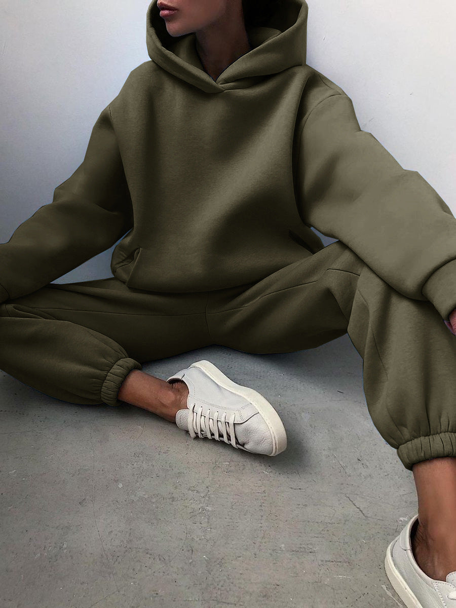 Vrouw in tweedelig joggingpak met hoodie
