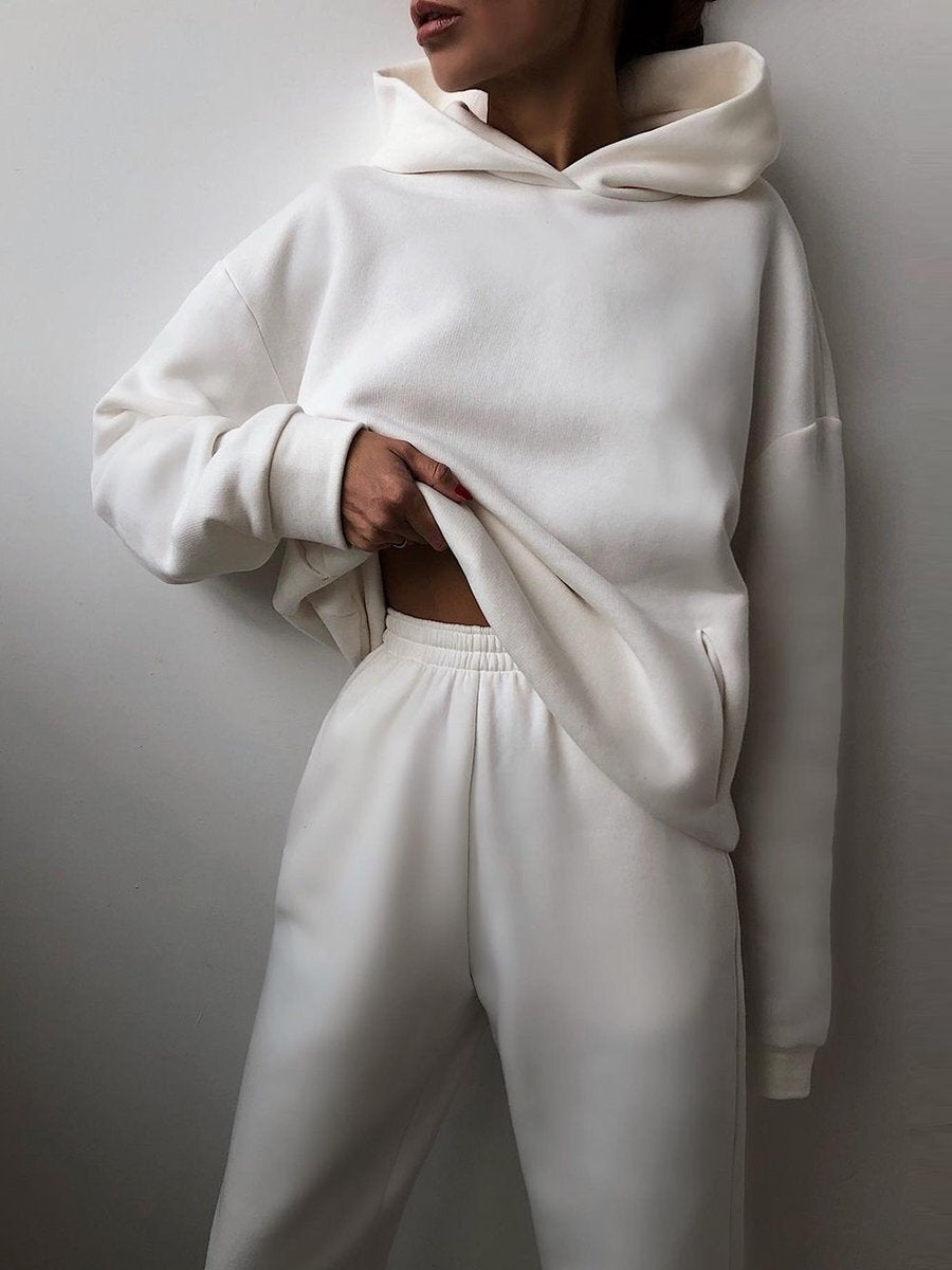 Vrouw in tweedelig joggingpak met hoodie
