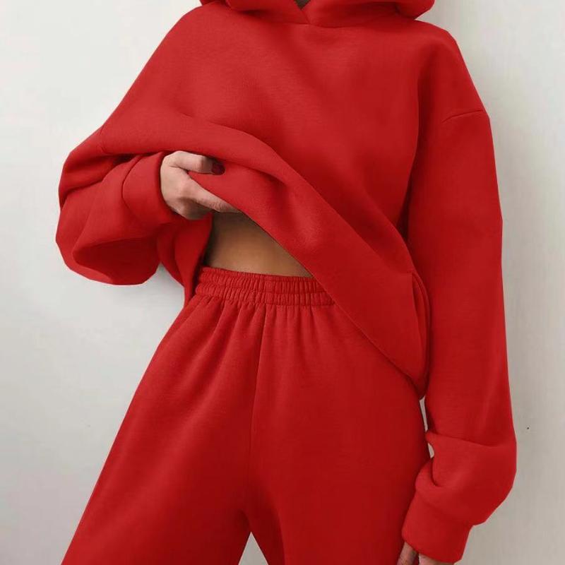 Vrouw in tweedelig joggingpak met hoodie