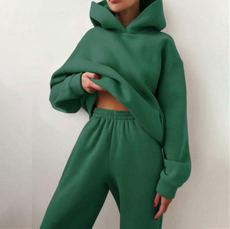 Vrouw in tweedelig joggingpak met hoodie