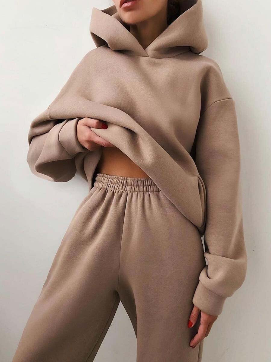 Vrouw in tweedelig joggingpak met hoodie