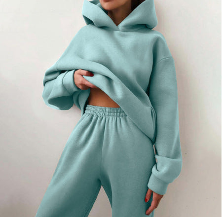 Vrouw in tweedelig joggingpak met hoodie