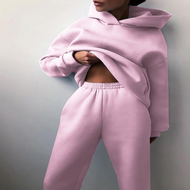 Vrouw in tweedelig joggingpak met hoodie