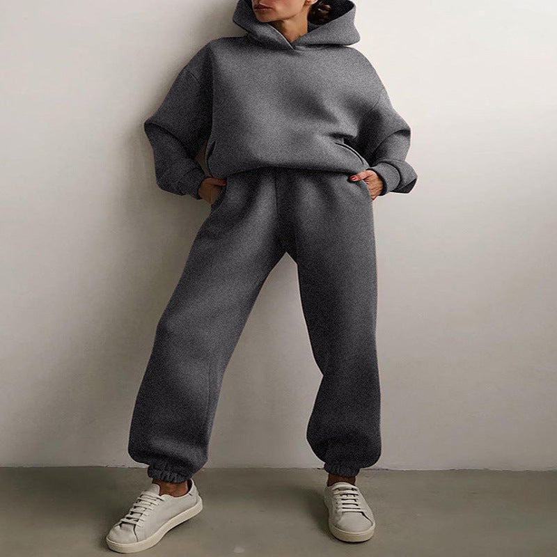 Vrouw in tweedelig joggingpak met hoodie