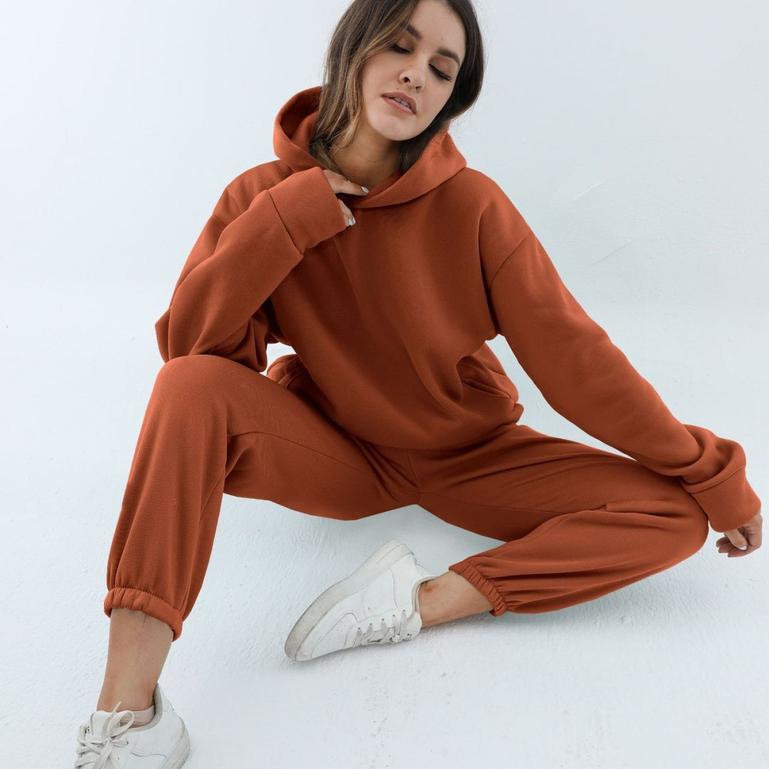 Vrouw in tweedelig joggingpak met hoodie